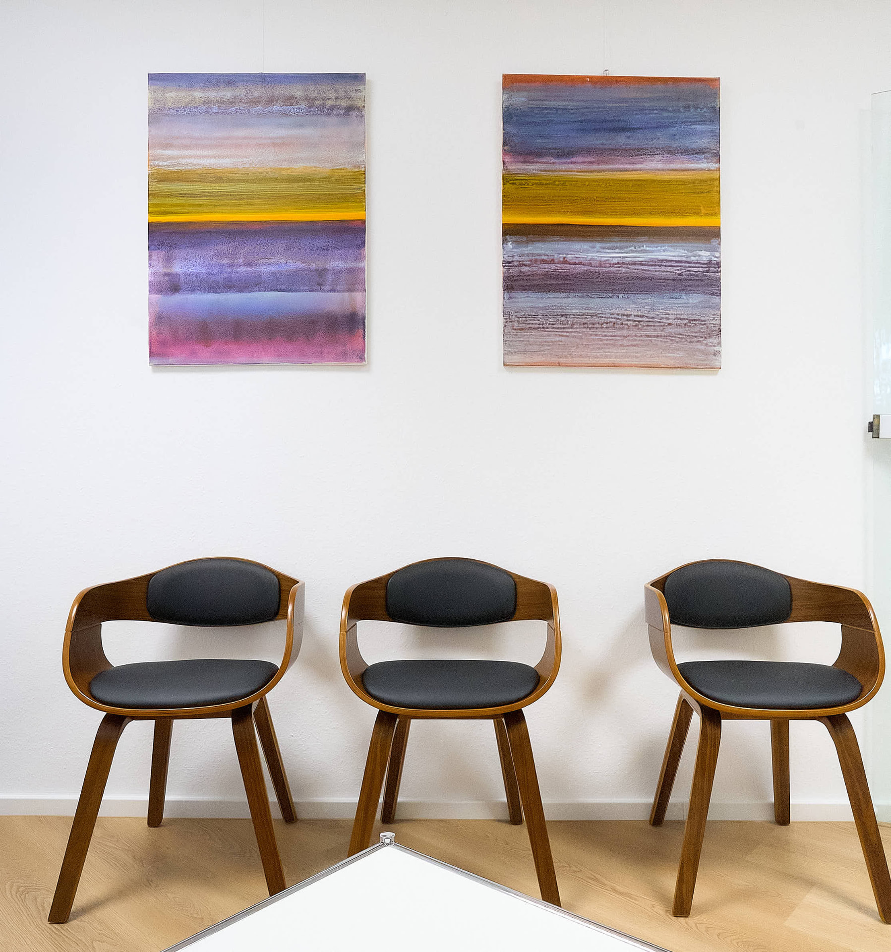 Wartezimmer der Augenarztpraxis in Bad Honnef mit Kunst und Holzstühlen
